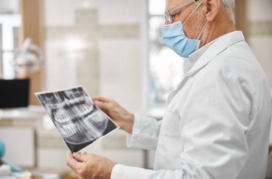 médico idoso analisando um exame de saúde