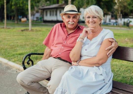 casal de turistas idosos sentados em praça pública