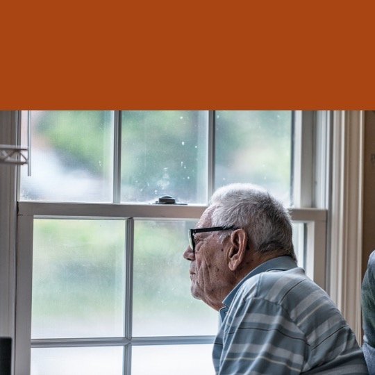 an older man sitting by a window