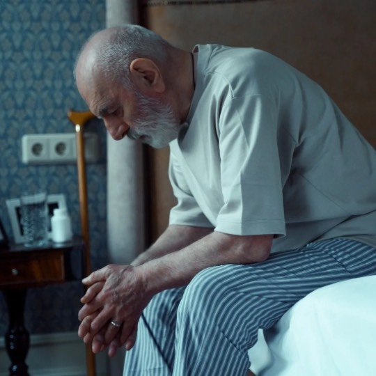 Idoso triste chorando sentado na cama
