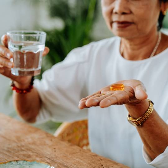 idosa tomando suplemento vitamina