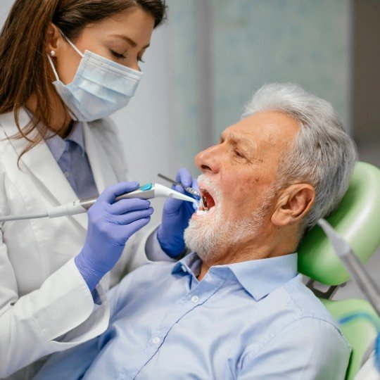 Idoso tratando seus dentes em consulta