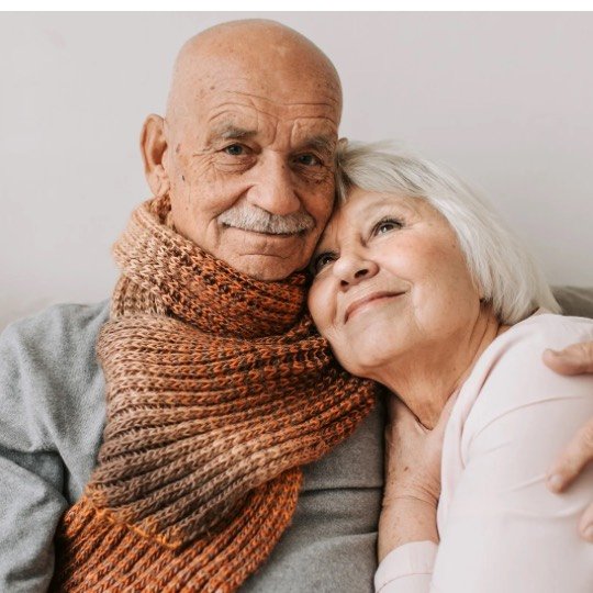 Casal de idosos posando abraçados para foto