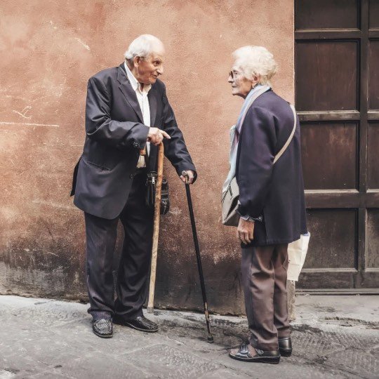 Casal de idosos conversando de pé