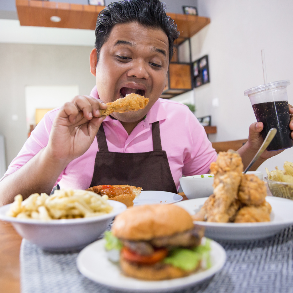 Homem se fartando de comer em mesa de refeição