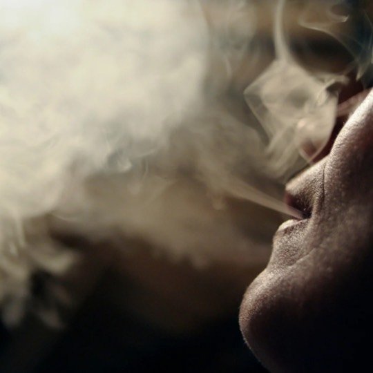 Foto perfil de mulher adulta fumando