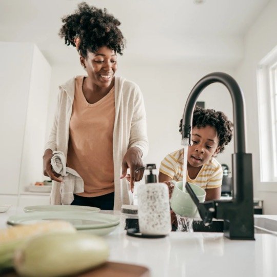 Mãe e filha lavando louça