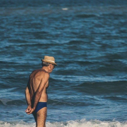 Idoso caminhando na praia