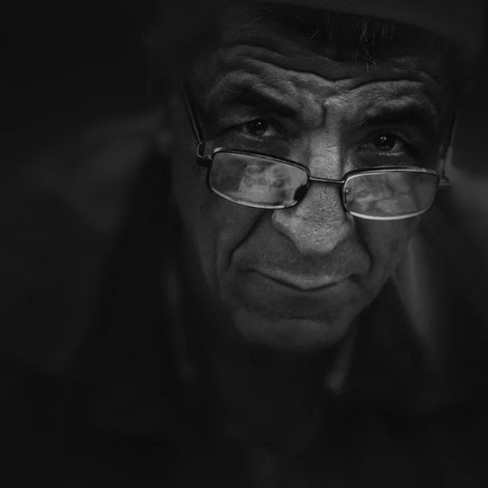 Imagem de rosto de idoso na penumbra