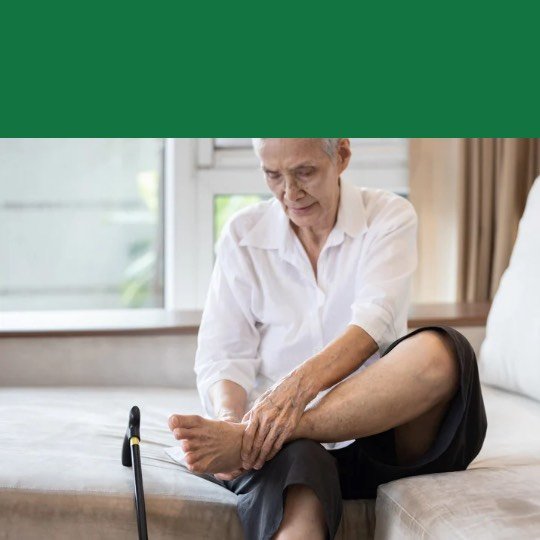 Idoso sentado segurando as pernas