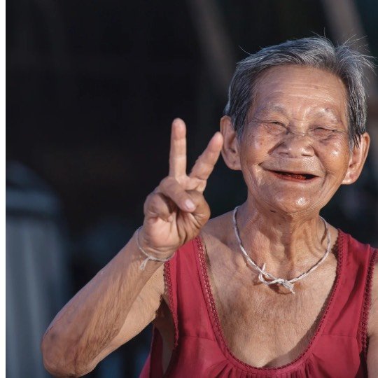 Idosa feliz fazendo com as mãos o V de vitória