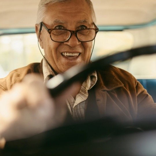 Idoso muito feliz e sorridente dirigindo automóvel