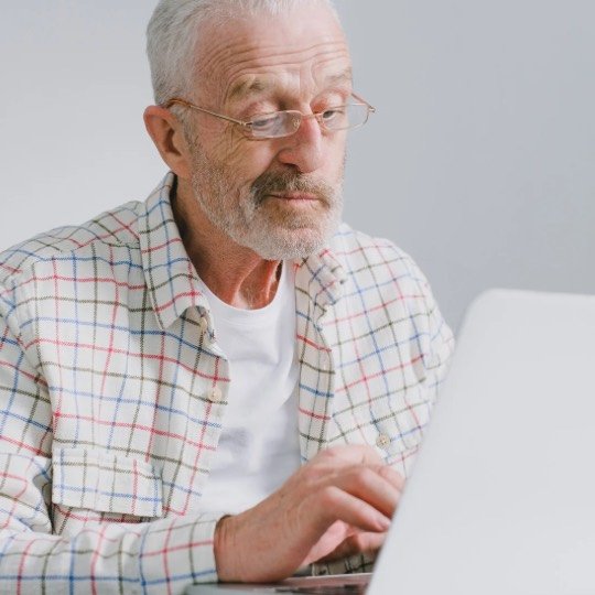 Idoso trabalhando em notebook