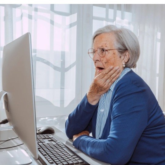 Idosa em frente ao computador em trabalho