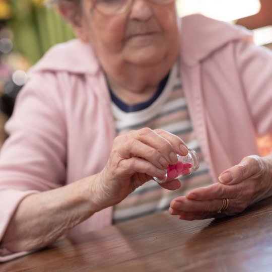 Idosa tomando suplemento vitamínico