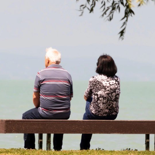 Casal de idosos sentados mirando o horizonte