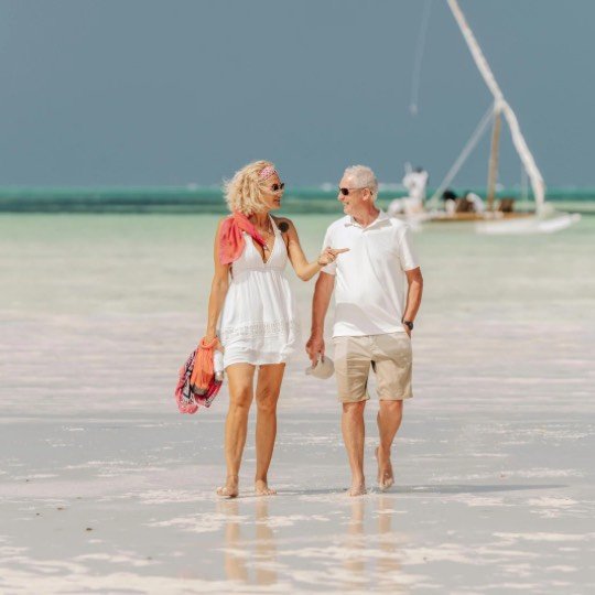 Casal de idosos passeando na praia